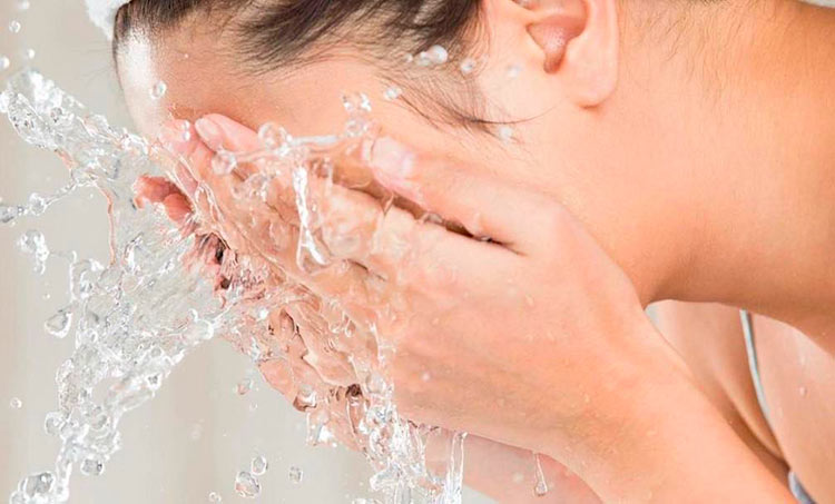 ragazza lava viso con acqua