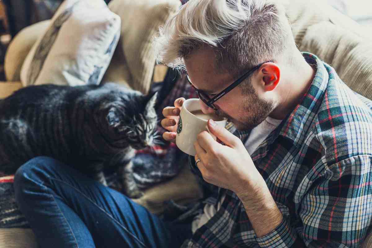 uomo che beve il caffè gatto