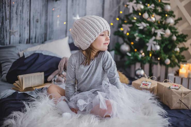 bambina di fronte all'albero di natale